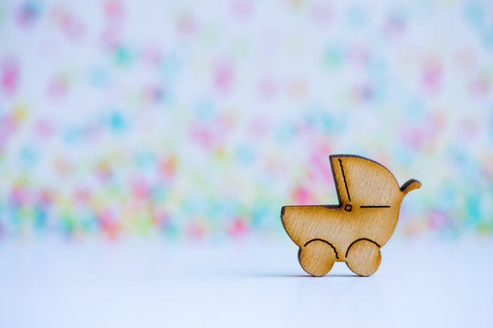 Wooden icon of baby buggy on colorful background