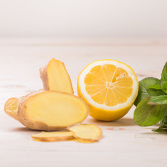 Ingredients for ginger lemonade: lemon, ginger, mint on a white wooden background. Detox water. Cleaning the body of toxins, vitamins