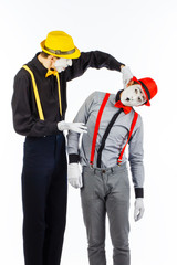Two young men, an actor, a MIME, in clothing and makeup, argue, and gesticulate on a white background.