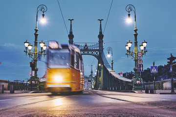 Naklejka premium Moving tram on the bridge in the Budapest city early morning