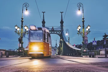 Zelfklevend Fotobehang Moving tram on the bridge in the Budapest city early morning © nickzudwa