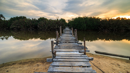 The old wooden bridge over a river at Kg. Pulau Kerengga, Marang Malaysia with sunset scenery