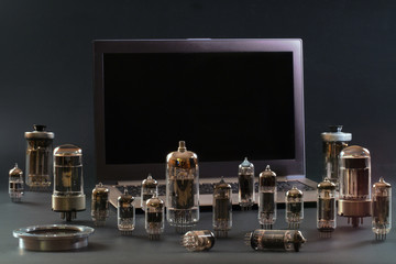 Radio tubes and a laptop on a black background