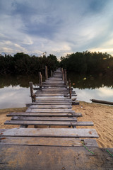 The old wooden bridge over a river at Kg. Pulau Kerengga, Marang Malaysia with sunset scenery
