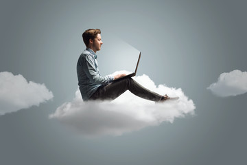 Mann arbeitet an seinem Notebook auf einer Wolke - 152448849