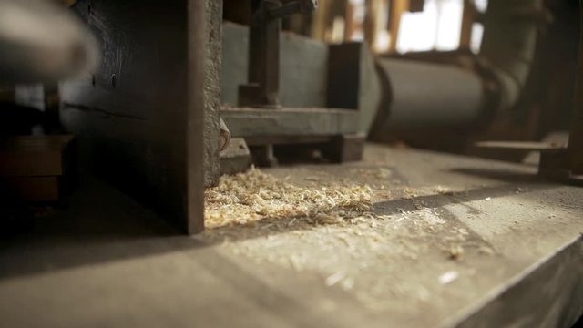 Close up footage in slowmotion with tilt. Wooden sawdust lying on table in joinery