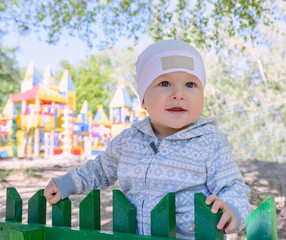 the child on the Playground, clinging to the fence.