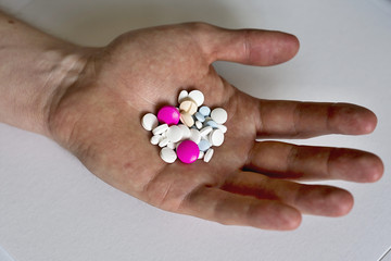 Heap of colorful medicines in his palm