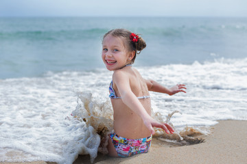 Lovely cheerful girl is happy at the seaside on vacation