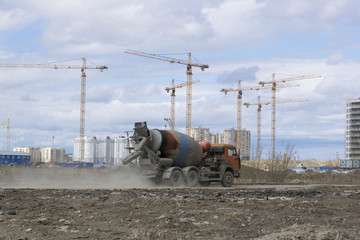 Fototapeta na wymiar Cranes and building construction site against blue cloudy sky.