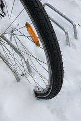 Vorderrad eines Fahrrads im Fahrradständer im Schnee
