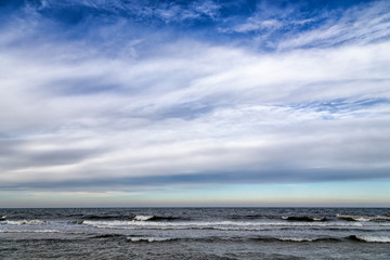 Idyllic panoramic view over stormy German Baltic Sea at Zingst in the winter with beautiful light and clouds.