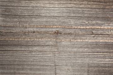 The relief texture of the surface of the old wooden board with poor processing, the expressive direction of the wood fibers and the cutoff point of the knot