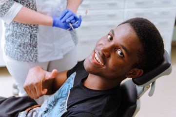 African patient in dentistry smiling in dental chair