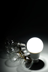 Glowing led lamp and incandescent bulbs in the dark