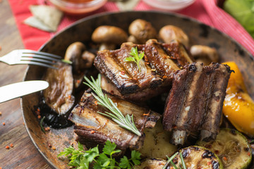 Ribs grilled in a frying pan with rosemary