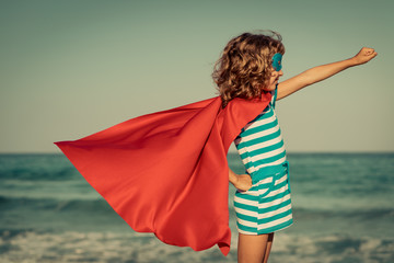 Superhero child on the beach. Summer vacation concept