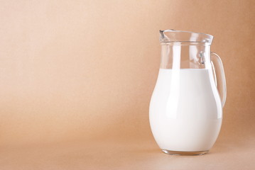 A jug of natural milk on a beige background