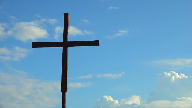 timelapse of iron Catholic Cross isolated on background of moving clouds
