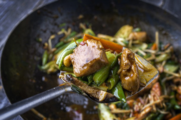 Traditional stir fried Chicken Gung Bao with Vegetable as close-up on Shovel