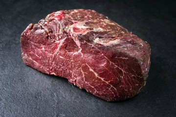 Dry aged raw Point Steak as close-up on a slate