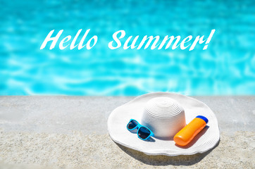 Hello Summer background with hat, sunglasses and sunscreen near the pool