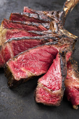 Barbecue dry aged Wagyu Tomahawk Steak sliced as close-up on old metal sheet