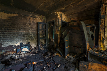 Fototapeta na wymiar Interior of a burnt by fire apartment in an apartment building, burned furniture 