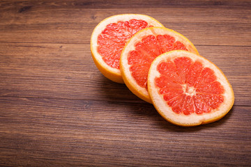 orange grapefruit on a wooden surface. arrangement of sliced fruit.