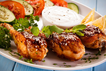 Grilled chicken drumstick on wooden table 