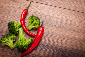 green broccoli, red chili on a wooden surface. Top view with copy space for text
