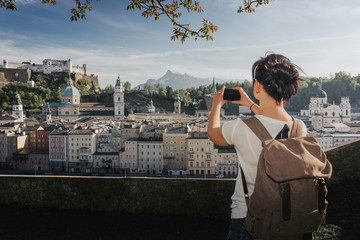 Austria. Salzburg. Young girl tourist taking pictures on mobile phone historic center of Salzburg World Cultural Heritage UNESCO