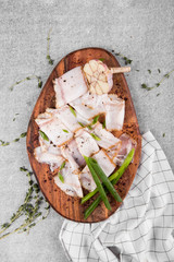 tasty bacon with spices on wooden cutting board on a gray background. flat lay. copy space