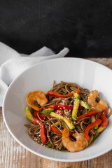 Noodles with vegetables and seafood on a wooden table Chinese-style noodles with vegetables and seafood. copy space