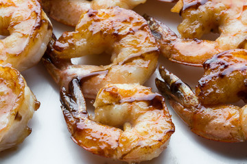 tasty spiced shrimp skewers on a barbecue. Close up
