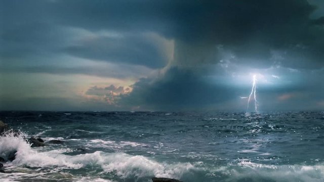Cinematic storm clouds with lightning strikes reflecting in ocean.