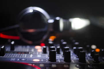 DJ Spinning, Mixing, and Scratching in a Night Club, Hands of dj tweak various track controls on...