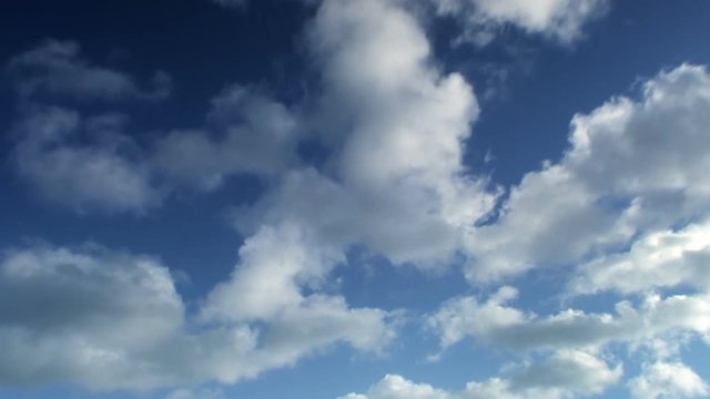 Timelapse of fluffy clouds on blue sky.