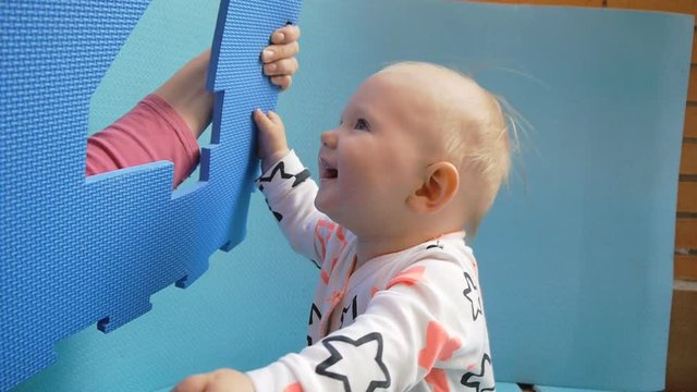 Baby and mother plays with eva puzzle mat