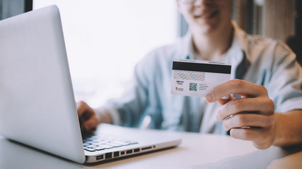 Young man working on a macbook or laptop in cafe