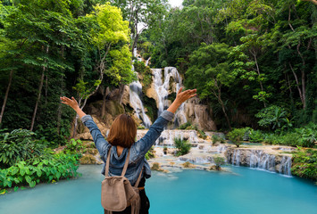 Women tourists wear jacket jeans at Tad Kwang Si Waterfall Land mark in Luang Prabang, Laos ,beautiful turquoise color water and Tropical forest  at Waterfall in north Lao