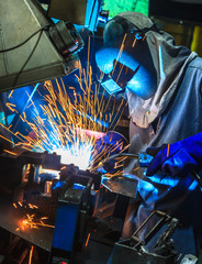 welder, welding automotive part in a car factory
