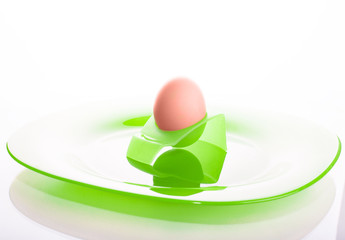 orange egg on green plate isolated on white background