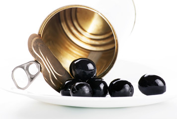 black olives on a white plate on a plate on a white background and a tin