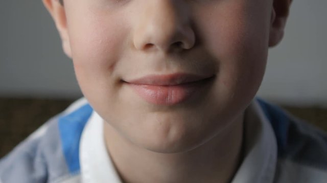 Close-up of the boy's lips. He is happy and smiling.