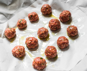 Raw uncooked meatballs on a baking sheet