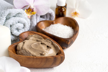 Spa setting with cosmetic clay mask for body and face, Towel and  Essential oil