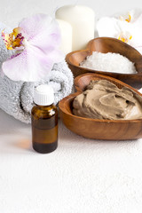 Fototapeta na wymiar Spa setting with cosmetic clay mask for body and face, Towel and Essential oil