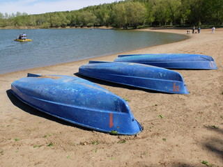 Inverted boats on the sandy shore of the lake