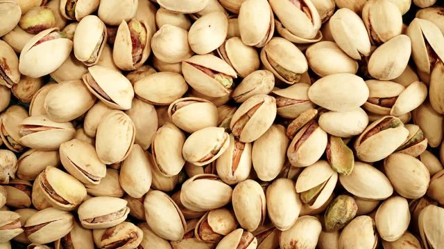 Food background. Roasted pistachio nuts seed with shell close up. Dieting concept. Dolly slider shot, rack focus 4K ProRes HQ codec